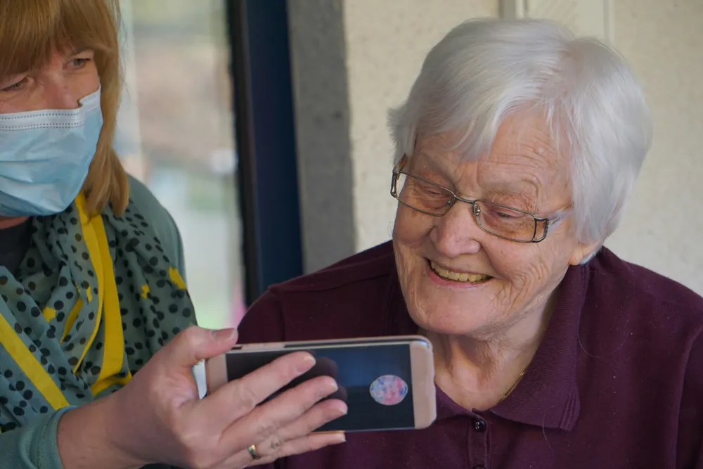 seniorin smartphone digitale teilhabe betreuung — Symbolbild zum Ratgeber „Nachts Hilfe noetig? Nachtpflege und Nachtbetreuung im Ueberblick“